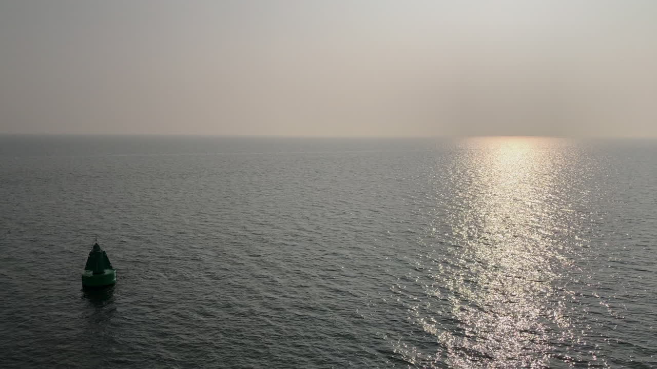 해가 뜰 때나 해가 뜰 때 수면 위로 떠 있는 바다 부표의 고요한 장면