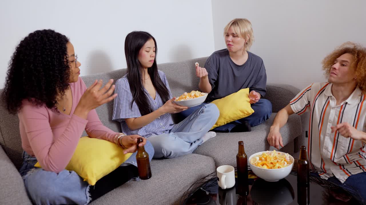Gruppo di amici che si godono snack e bevande sul divano