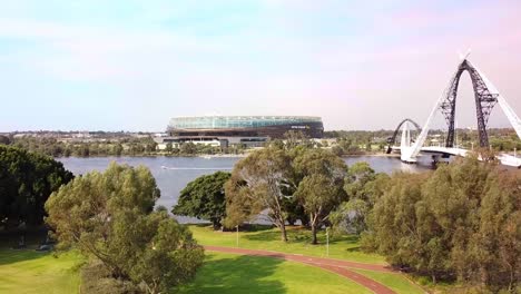 aerial rise up view of perth stadium and the matagarup pedestrian bridge over the swan river