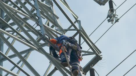 electrician works at dangerous height, climbs high voltage power line for maintenance