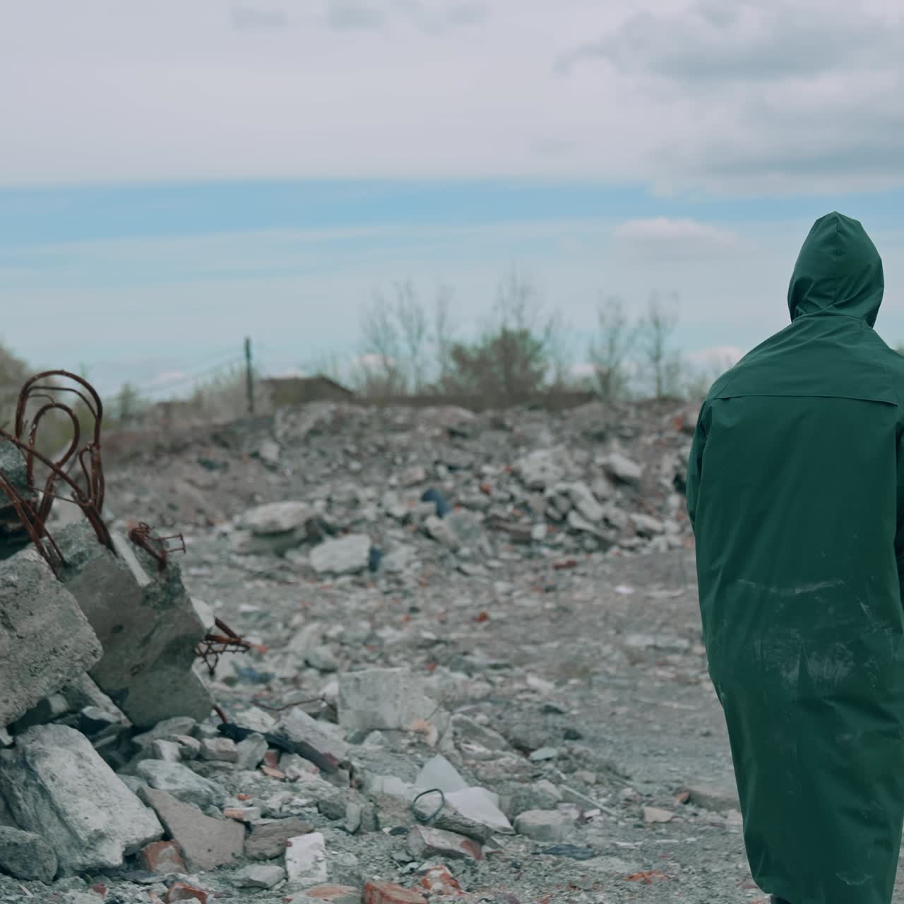 Virologist man in protective costume and respirator gas mask walking near landfill site pollution and looking at the scale of the disaster. Ecological disaster concept