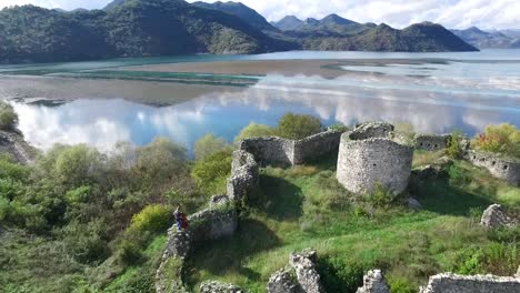 aerial view of the ruins of a castle on the shore of a lake