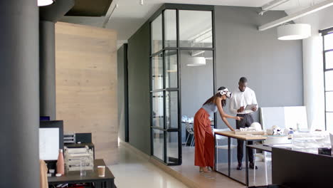 business diverse colleagues discussing work, using tablet and documents in modern office