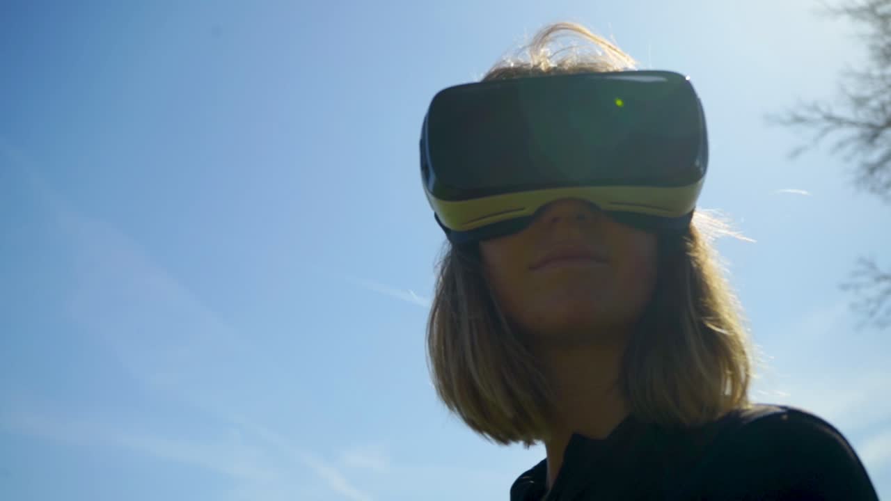 mujer joven usando auriculares de realidad virtual al aire libre