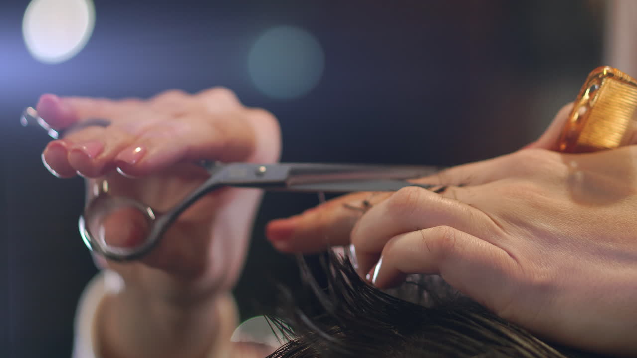 Hairdresser cutting hair with professional scissors and comb in hairdressing salon. Close up haircutter making male haircut with scissors in hairdressing school