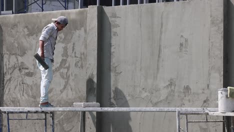 worker applying plaster on a large vertical surface