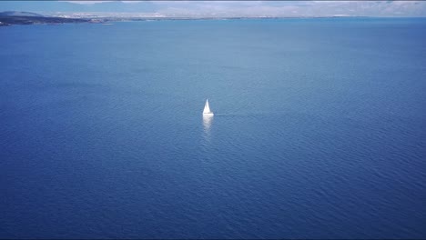 Bellas-Imágenes-De-Un-Velero-Blanco-En-Aguas-Turquesas-Con-Vistas-A-Las-Montañas-En-El-Horizonte