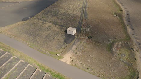 Toma-Aérea-Orbital-De-Un-Pequeño-Bloque-De-Cabañas-Al-Lado-De-La-Carretera-En-El-Parque-Nacional-De-Las-Grietas-En-Lanzarote