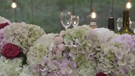 arch for the newlyweds is decorated with flowers and glasses