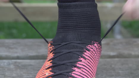hombre atando zapatos de fútbol en cámara lenta, primer plano