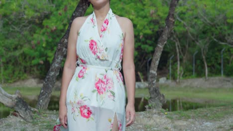 Descending-camera-movement-of-a-young-girl-walking-while-wearing-a-long-flower-dress