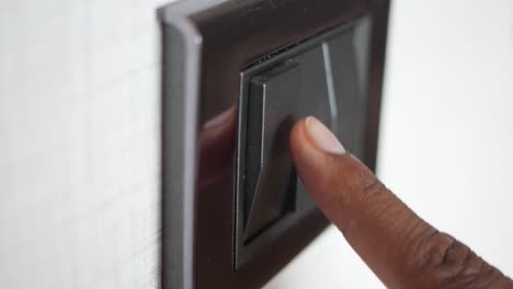 una mano encendiendo un interruptor de luz