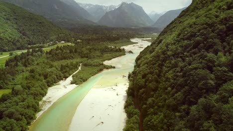 aerial view of soca river surrounded by many hills and vegetation in slovenia.