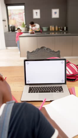 vertical video of african american girl in online class using laptop with copy space, slow motion
