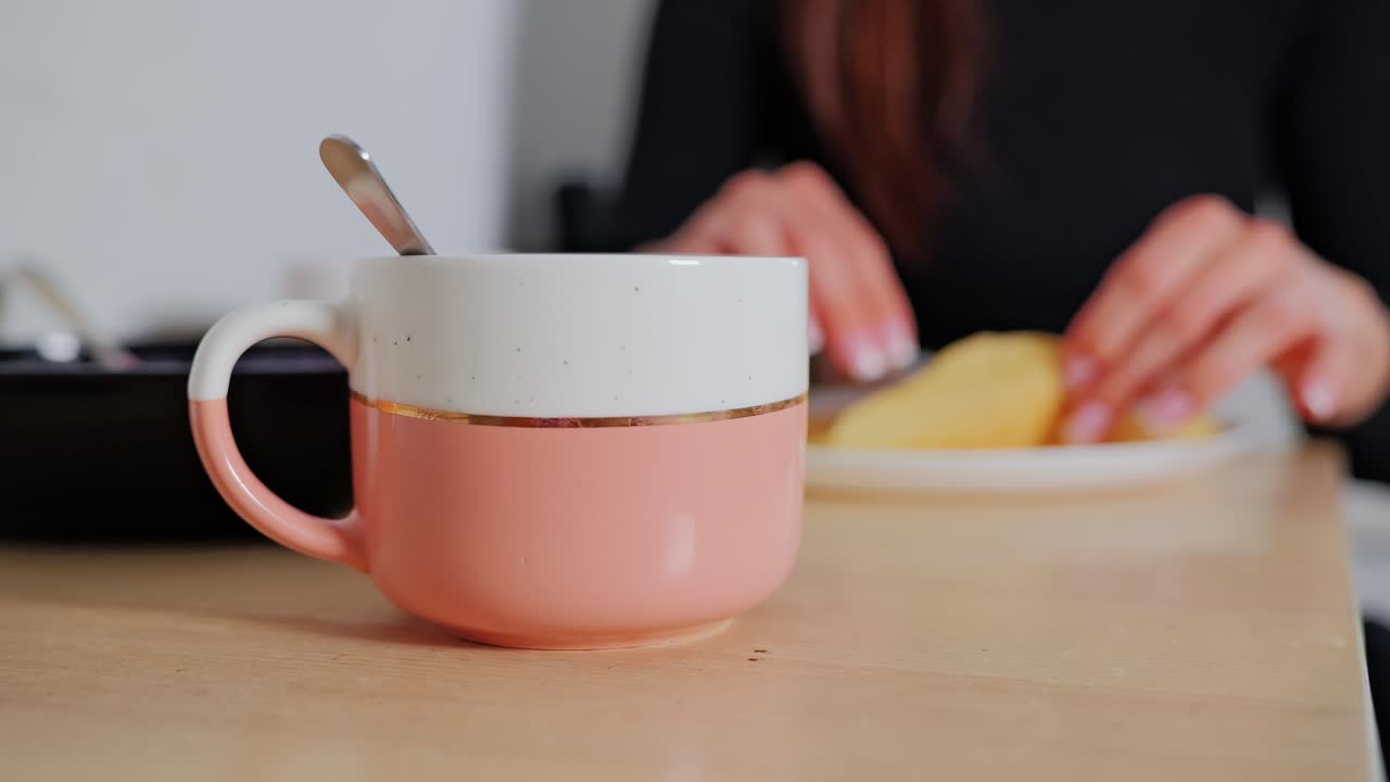 Statisk nærbilde viser fokus på en varm kopp med en myk frokostrutine i bakgrunnen