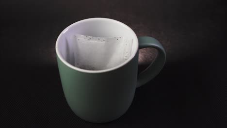 making and pouring hot tea in a mug