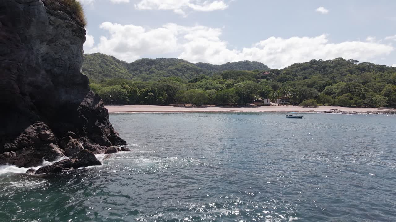 toma de cierre lejos de la playa real pasando por una pequeña isla formada por rocas