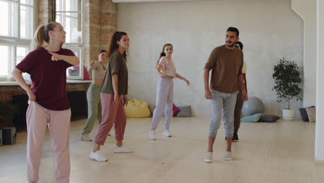 female trainer and group of multiethnic students dancing in studio