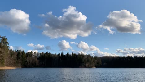 camping site by tranquil lake under cloudy blue sky - wide shot