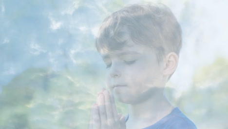 animación de un niño orando sobre un cielo azul y nubes en movimiento