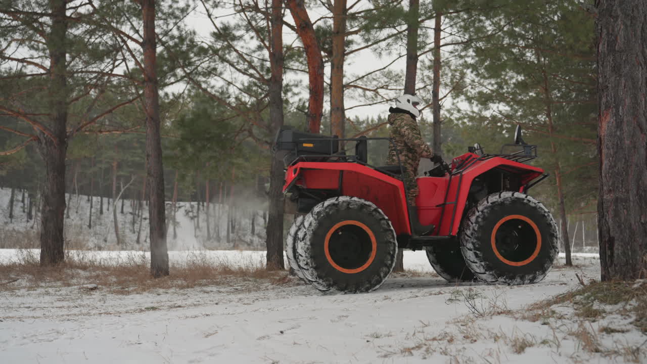 ATV rosso che derapa attraverso una pineta, il pilota si inclina in curva, pneumatici larghi che sollevano neve e lasciano tracce profonde, acceleratore offroad aggressivo e ruote posteriori che slittano, atmosfera invernale tesa.