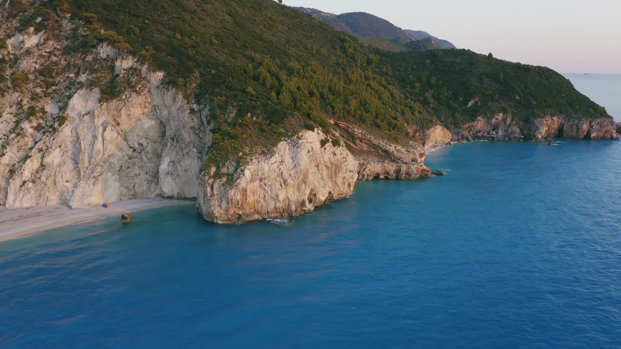 воздушный вид на красивый пляж милос и скалы лефкады, ионический остров, греция. закат золотой солнечный свет и бирюзово-голубое море залива
