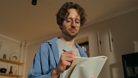 man writing in notebook