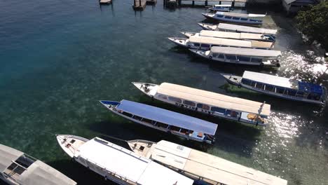 Toma-Aérea-Inclinada-Hacia-Arriba-De-Botes-De-Estacionamiento-En-La-Orilla-Del-Mar