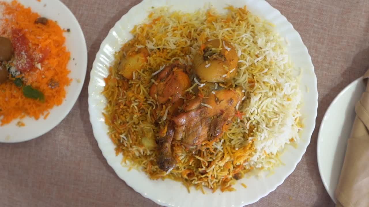 caliente delicioso hyderabadi biryani servido con arroz dulce zarda de india y pakistán, cámara lenta