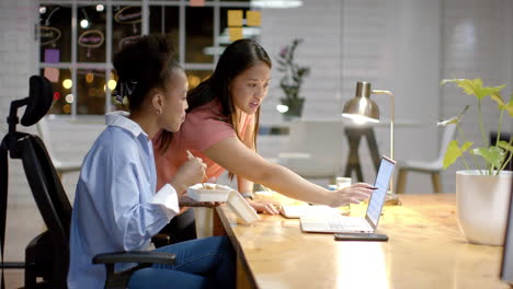 Young-African-American-woman-and-biracial-woman-collaborate-in-a-modern-business-office