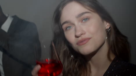 attractive woman dancing with drink at party with black man