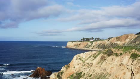 Aerial-Shot-ascending-above-cliffs-of-Palos-Verdes-Coastline-with-Point-Vicente-Lighthouse-in-background