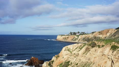 toma aérea ascendiendo por encima de los acantilados de la costa de palos verdes con el faro de punto vicente en segundo plano