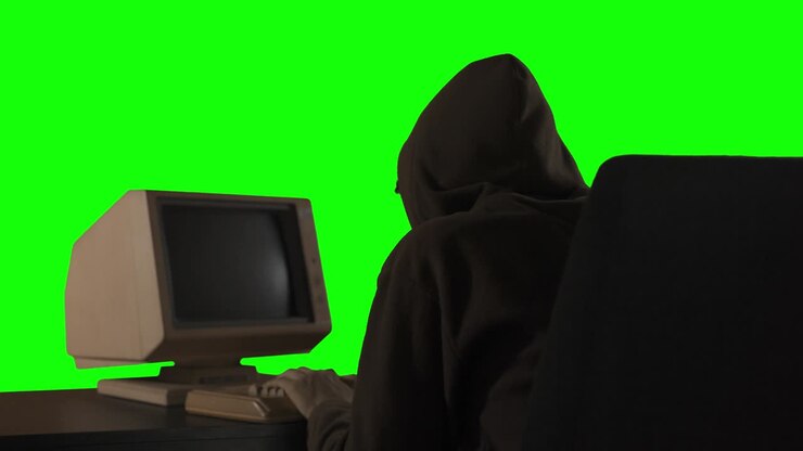 Uomo incappucciato che viola dati segreti da un vecchio computer
