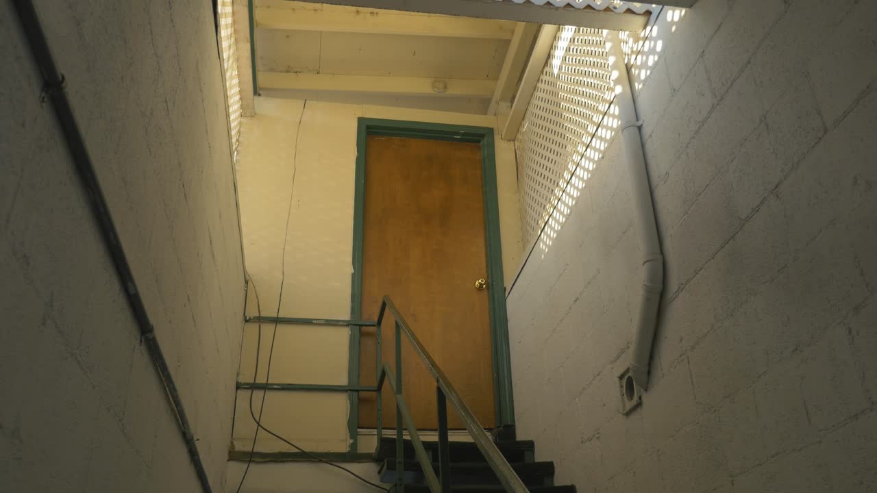 A wooden door at the end of a stairway.