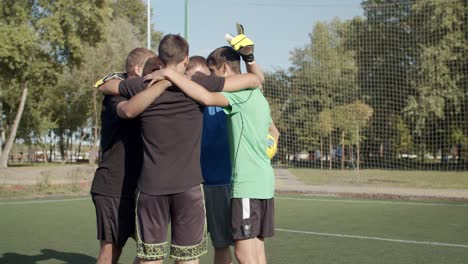 street soccer team embracing before football game