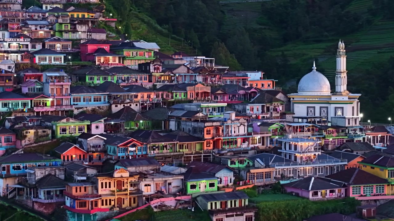 Endonezya'nın Nepal Van Java bölgesinde, sakin bir tropikal ortamda cami, teraslı tepeler ve renkli kırsal evlerle dolu çarpıcı bir dağ köyü panoramasının havadan görünümü.