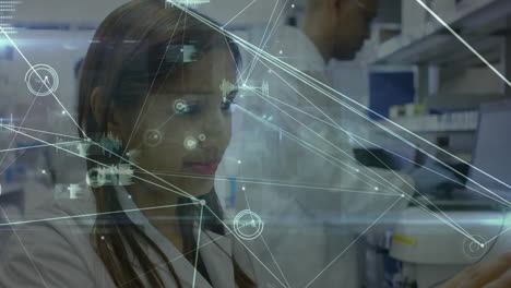 Animation-of-network-of-connections-over-caucasian-female-doctor-using-tablet