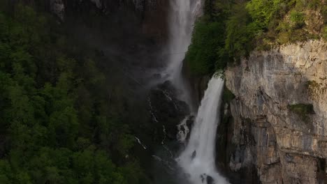 Seerenbach-Falls-in-Switzerland-features-three-cascading-waterfalls-flowing-down-a-lush,-green-cliffside-surrounded-by-dense-forest