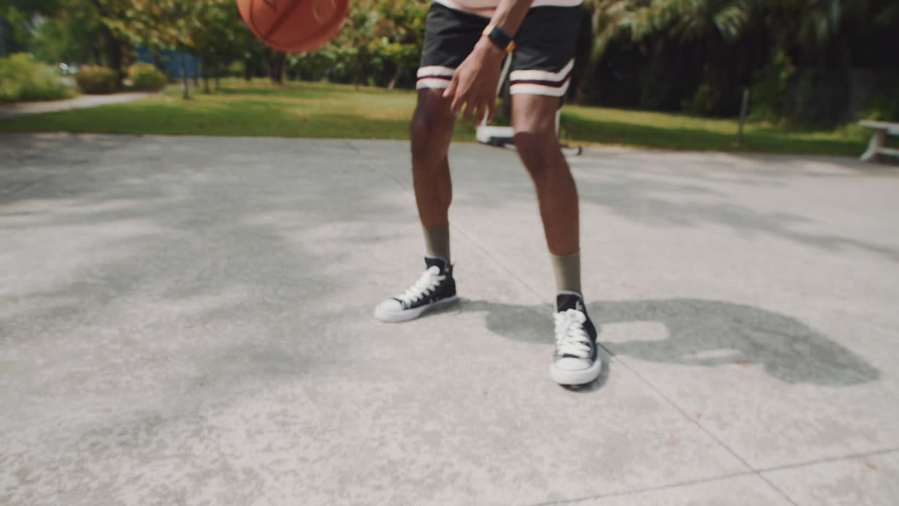 Male Player Bouncing Ball on Floor during Streetball Game with Friend