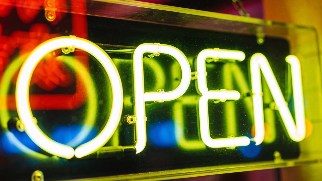 Powering green-yellow OPEN sign staying lit in shop window, shifting halos and signaling open
