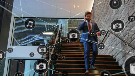 network of digital icons against caucasian businessman climbing down the stairs at office