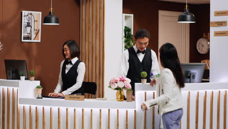 Front-desk-team-staff-welcoming-hotel-guest-at-reception