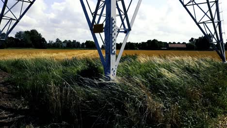 Smooth-shot-of-high-voltage-pylon-from-low-to-high,-'s-Gravenpolder,-Zeeland,-Netherlands