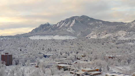 Tiro-Alto-De-Drones-Moviéndose-A-La-Izquierda-De-Boulder-Colorado-Y-Montañas-Rocosas-Flatiron-Después-De-Una-Gran-Tormenta-De-Nieve-Invernal-Cubre-árboles,-Casas,-Calles-Y-Vecindarios-En-Nieve-Blanca-Fresca-Para-Las-Vacaciones