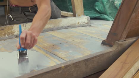 Mann-Malt-Geschliffene-Teakholzdeckplanken-Mit-Holzgrundierung-Auf-Aluminiumbasis