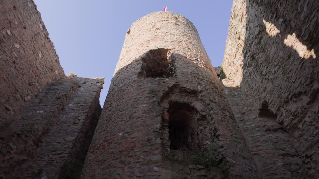 Borgtårnets indre rejser sig over ruinerede mure i Saarburg, Tyskland, set fra lav vinkel.