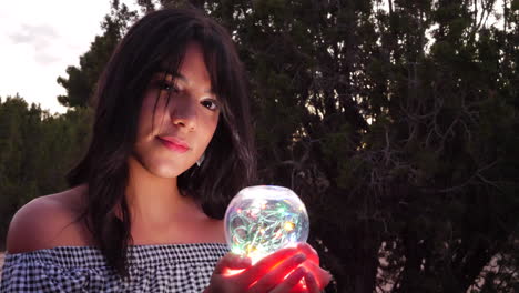 A mysterious fortune teller with a magic crystal ball glowing in a fantasy land