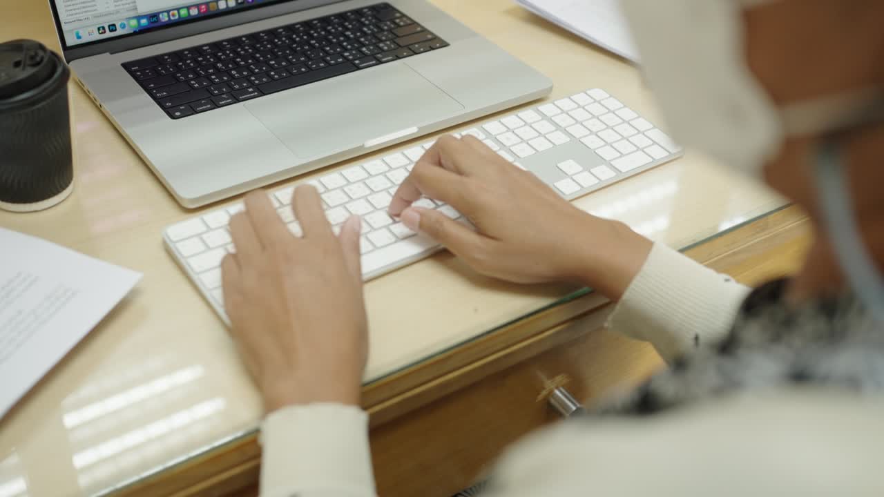 руки бизнесменки набирают на клавиатуре ноутбука для поиска информации, маркетинговых исследований, отчета в офисном столе