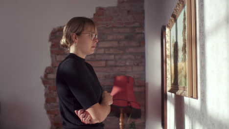 woman observing art in a home setting